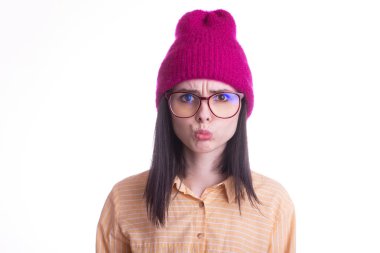 Gömlekli güzel duygusal bir kız ve beyaz arka planda pembe bir şapka.