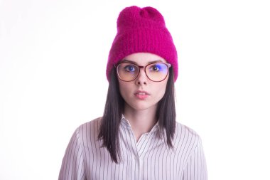 Gömlekli güzel duygusal bir kız, görüş gözlüğü ve beyaz arka planda pembe bir şapka.