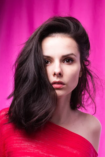 beautiful girl in a pink sweater, pink background