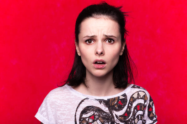 beautiful emotional girl in a t-shirt on a red background