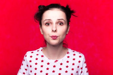 Kırmızı arka planda tişörtlü güzel duygusal kız.