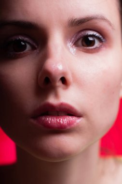 Kırmızı arka planda güzel bir kız. Yakın plan portresi.