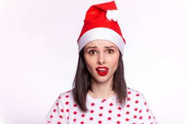 Tişörtünde yıldız ve Noel Baba şapkası olan dudaklarında kırmızı ruj lekesi olan güzel bir kız.