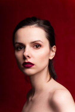 Dudaklarında kırmızı ruj, kırmızı arka planı olan güzel bir kız.