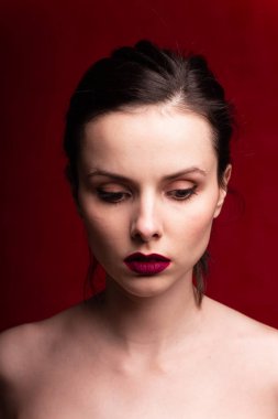 Dudaklarında kırmızı ruj, kırmızı arka planı olan güzel bir kız.