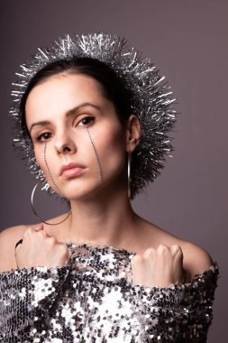 Güzel bir elbise içinde güzel bir kız. Yüzünde yapay elmaslar olan parlak bir daire.