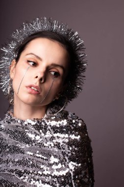 Güzel bir elbise içinde güzel bir kız. Yüzünde yapay elmaslar olan parlak bir daire.