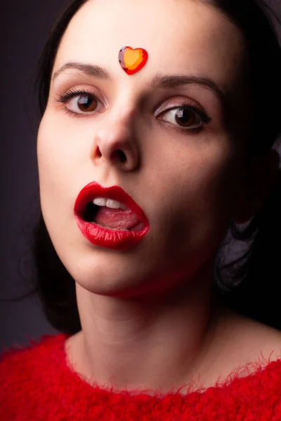 Девушка Красном Свитере Красными Губами Красным Сердцем Лице — стоковое фото