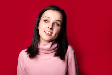 Kırmızı arka planda pembe balıkçı yakalı güzel bir kız.