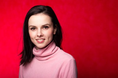 Kırmızı arka planda pembe balıkçı yakalı güzel bir kız.