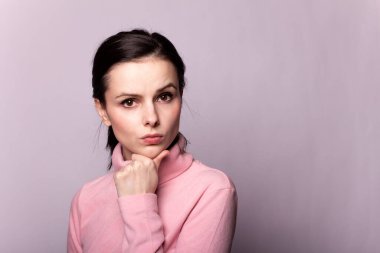 Gri bir arka planda pembe balıkçı yakalı güzel bir kız.