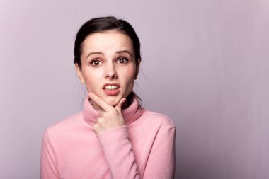 Gri bir arka planda pembe balıkçı yakalı güzel bir kız.