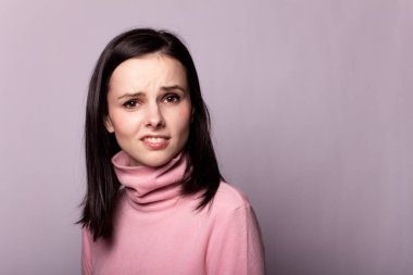 Gri bir arka planda pembe balıkçı yakalı güzel bir kız.