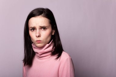 Gri bir arka planda pembe balıkçı yakalı güzel bir kız.