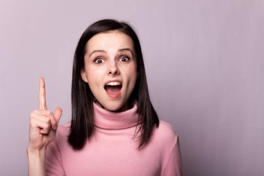 Gri bir arka planda pembe balıkçı yakalı güzel bir kız.