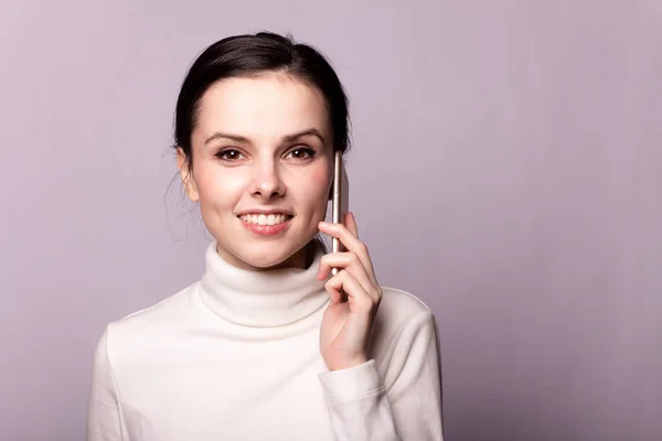 Menina Uma Gola Alta Branca Falando Telefone Retrato Fundo Cinza — Fotografia de Stock