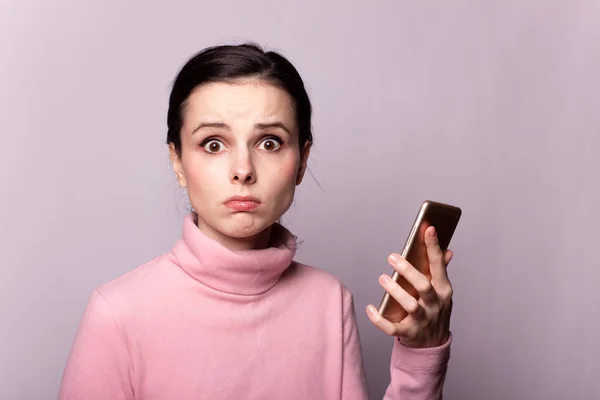 Gri arka planda telefonla konuşan pembe balıkçı yakalı güzel bir kız.