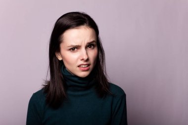 Gri bir fotoğrafta yeşil balıkçı yakalı güzel bir kız.