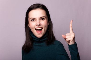 Gri bir fotoğrafta yeşil balıkçı yakalı güzel bir kız.