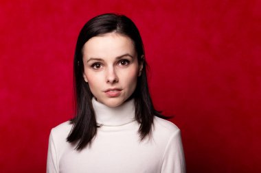 Beyaz balıkçı yakalı bir kız, kırmızı arka planda bir portre