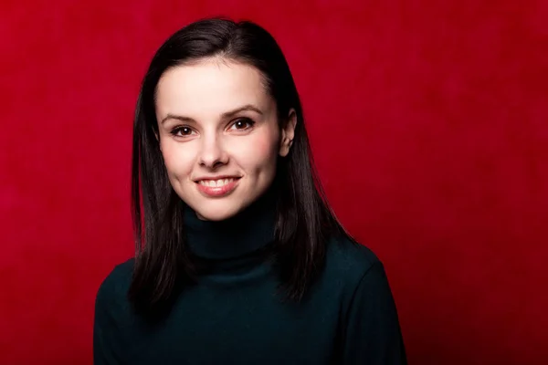 girl in a green turtleneck, portrait on a red background