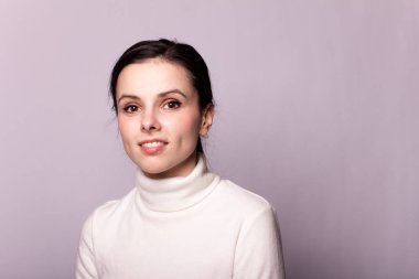 Beyaz balıkçı yakalı bir kız, gri arka planda bir portre.