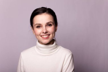 Beyaz balıkçı yakalı bir kız, gri arka planda bir portre.