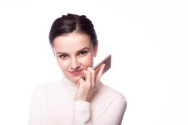 Beyaz balıkçı yakalı bir kız telefonda konuşuyor, beyaz arka planda bir portre.