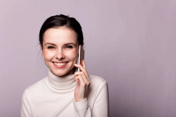 Menina Uma Gola Alta Branca Falando Telefone Retrato Fundo Cinza — Fotografia de Stock