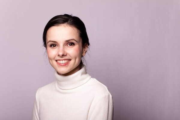 girl in a white turtleneck, portrait on a gray background