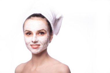 Kafasında beyaz havluyla yüzünde maske olan bir kız.