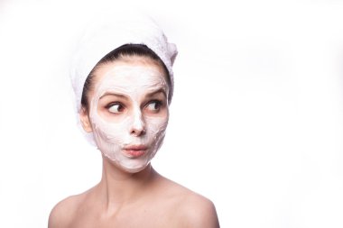 Kafasında beyaz havluyla yüzünde maske olan bir kız.