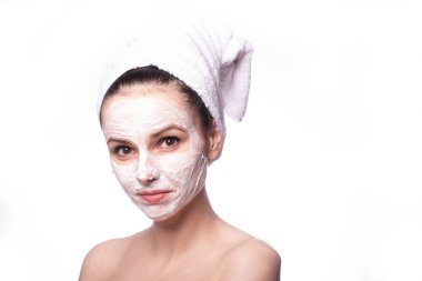 Kafasında beyaz havluyla yüzünde maske olan bir kız.