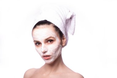 Kafasında beyaz havluyla yüzünde maske olan bir kız.