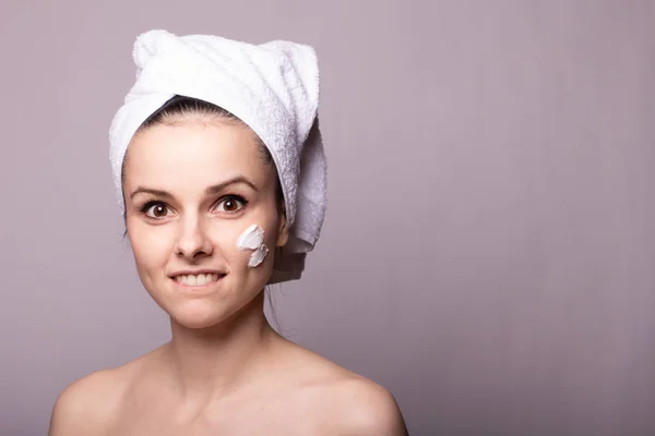 Meisje Met Een Witte Handdoek Haar Hoofd Crème Haar Gezicht — Stockfoto