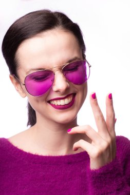 Mor kazaklı kız, mor gözlüklü dudaklarında mor ruj izi olan.