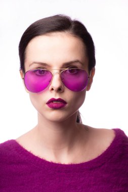 Mor kazaklı kız, mor gözlüklü dudaklarında mor ruj izi olan.