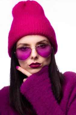 Mor kazaklı kız, pembe şapkalı dudaklarında mor ruj izi olan mor gözlükler.