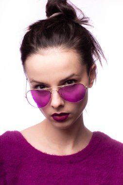 Mor kazaklı kız, mor gözlüklü dudaklarında mor ruj izi olan.