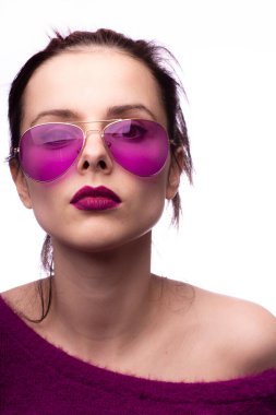 Mor kazaklı kız, mor gözlüklü dudaklarında mor ruj izi olan.