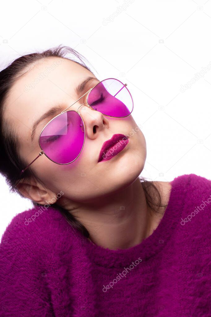 girl in a purple sweater, purple glasses with purple lipstick on her lips