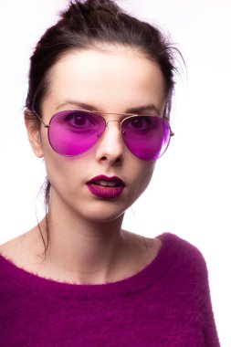Mor kazaklı kız, mor gözlüklü dudaklarında mor ruj izi olan.