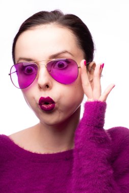 Mor kazaklı kız, mor gözlüklü dudaklarında mor ruj izi olan.