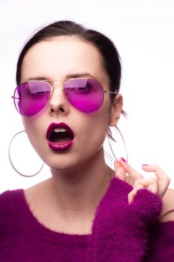 Mor kazaklı kız, mor gözlüklü dudaklarında mor ruj izi olan.
