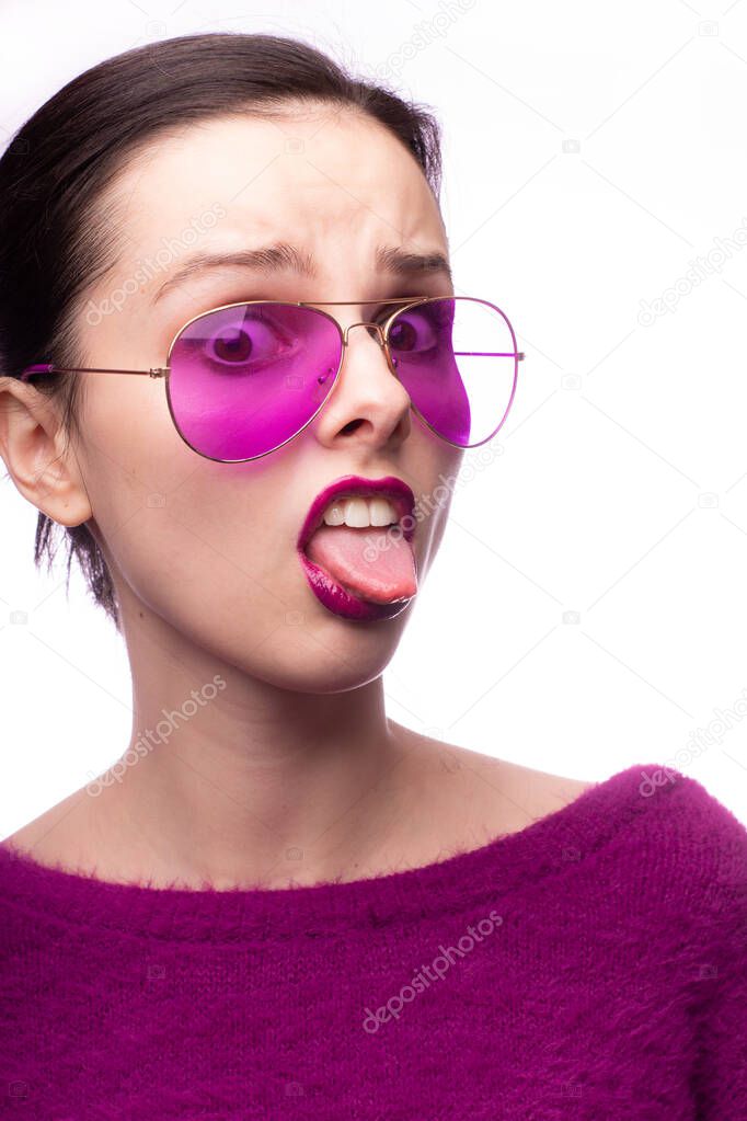 girl in a purple sweater, purple glasses with purple lipstick on her lips