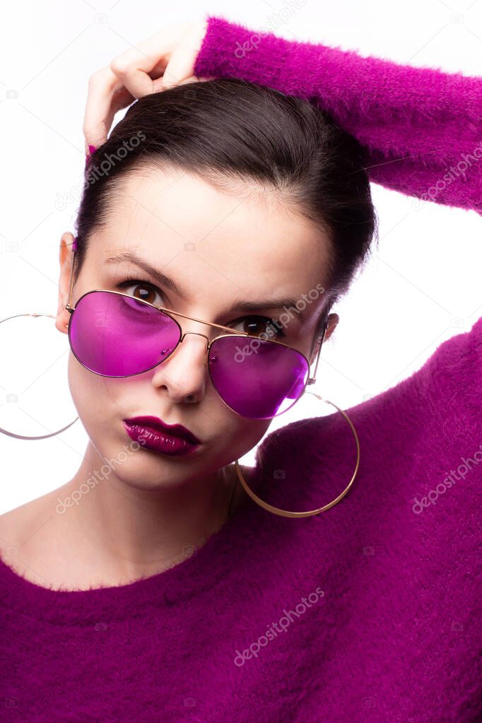 girl in a purple sweater, purple glasses with purple lipstick on her lips