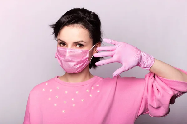 girl in a pink sweater and a pink mask and gloves