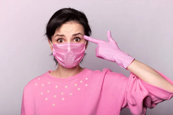 girl in a pink sweater and a pink mask and gloves