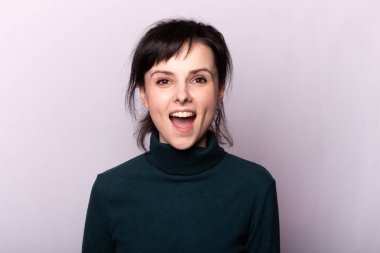 Gri bir fotoğrafta yeşil balıkçı yakalı güzel bir kız.