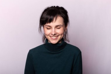 Gri bir fotoğrafta yeşil balıkçı yakalı güzel bir kız.